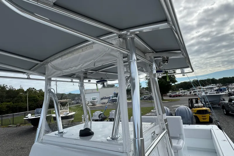 Slide: The Image of 2022 Contender 32 ST boat with sleek T-top design in a marina setting. - 23