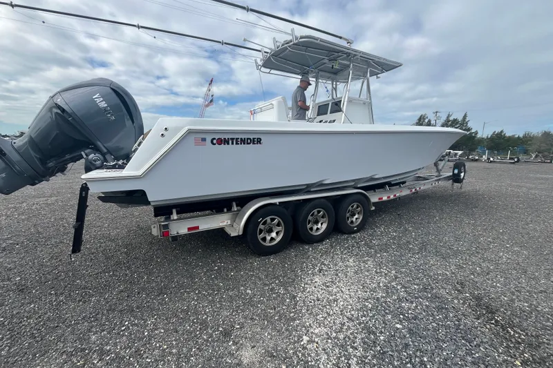 Slide: The Image of 2022 Contender 32 ST boat on trailer with Yamaha engine, parked outdoors. - 24