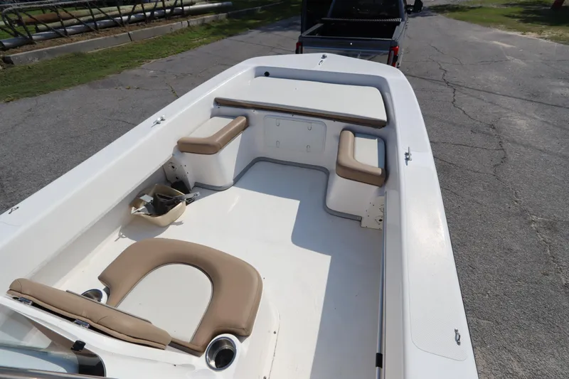 Slide: The Image of 2022 Sundance DX22 boat interior with beige seating and white deck. - 12