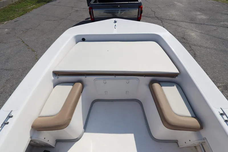 Slide: The Image of 2022 Sundance DX22 boat interior with cushioned seating and storage compartments. - 13