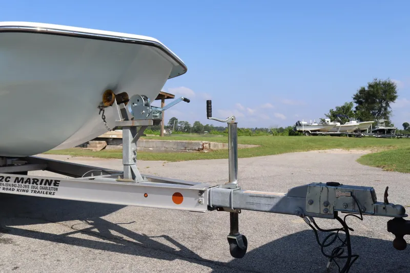 Slide: The Image of 2022 Sundance DX22 boat on trailer, parked outdoors on a sunny day. - 5