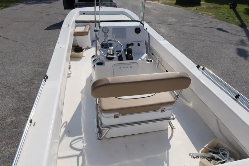 Slide: The Image of 2022 Sundance DX22 boat interior with steering console and seating. - 6
