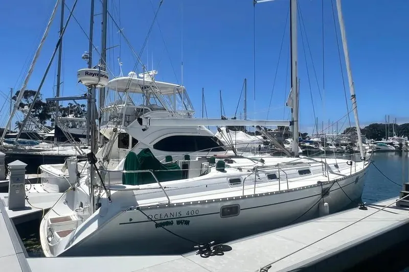 The Image of 1996 Beneteau Oceanis 400 sailboat docked at marina under clear blue sky. - 0