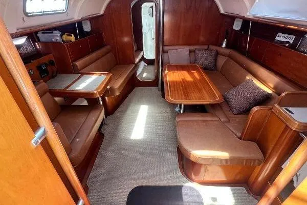 Slide: The Image of Interior of 1996 Beneteau Oceanis 400 yacht with wooden furnishings and cozy seating area. - 10