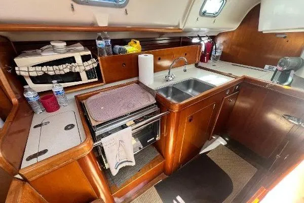 Slide: The Image of Interior of 1996 Beneteau Oceanis 400 yacht kitchen with wooden cabinetry and dual sink. - 16