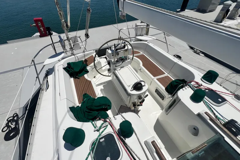 Slide: The Image of Cockpit of 1996 Beneteau Oceanis 400 sailboat with wooden seating and green covers. - 6