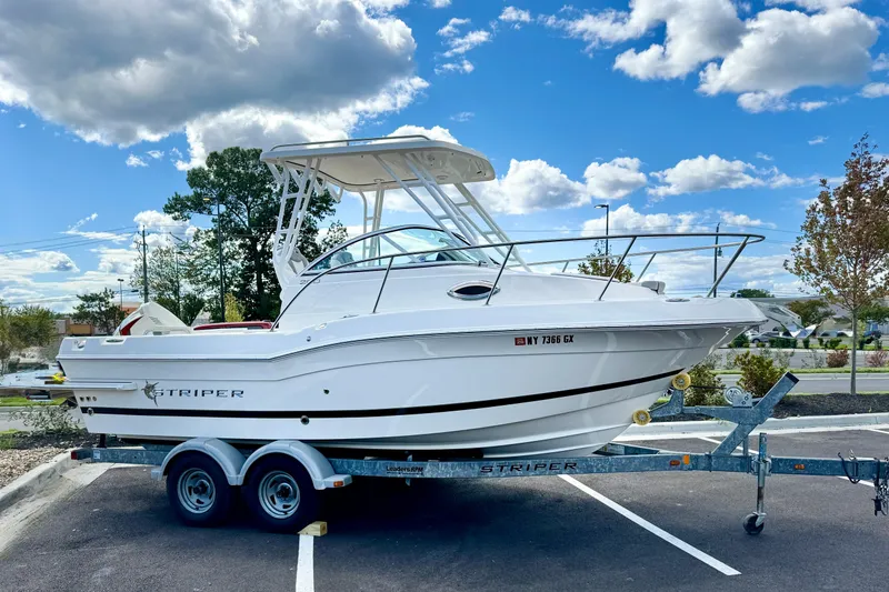 Slide: The Image of 2016 Striper 200 Walkaround boat on trailer under a blue sky. - 3