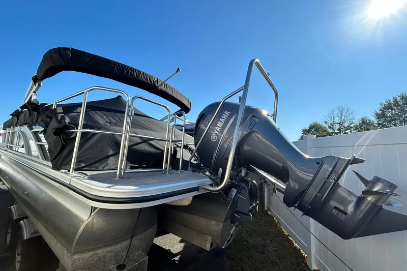 Slide: The Image of 2023 Bennington L 23 Swingback pontoon boat with Yamaha outboard motor under clear blue sky. - 11