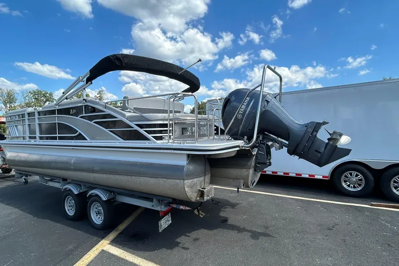 Slide: The Image of 2023 Bennington L 23 Swingback pontoon boat on trailer, featuring Yamaha outboard motor. - 12