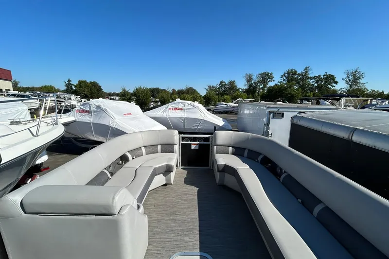 Slide: The Image of 2023 Bennington L 23 Swingback pontoon boat with spacious seating, docked outdoors. - 21