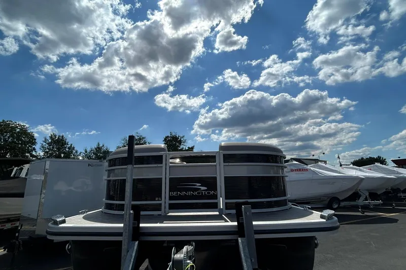 Slide: The Image of 2023 Bennington L 23 Swingback pontoon boat under a partly cloudy sky. - 4