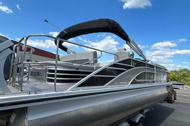 Slide: The Image of 2023 Bennington L 23 Swingback pontoon boat under a clear blue sky. - 5