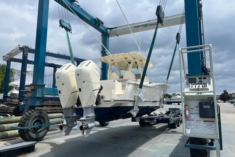 Slide: The Image of 2026 Scout 330 LXF boat on lift, showcasing dual engines and sleek design. - 10