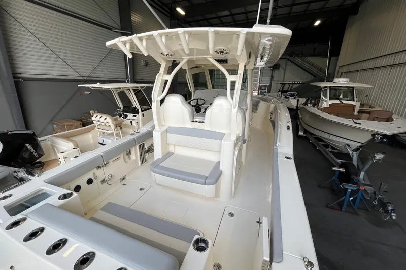 Slide: The Image of 2026 Scout 330 LXF boat interior in showroom, featuring seating and control area. - 14