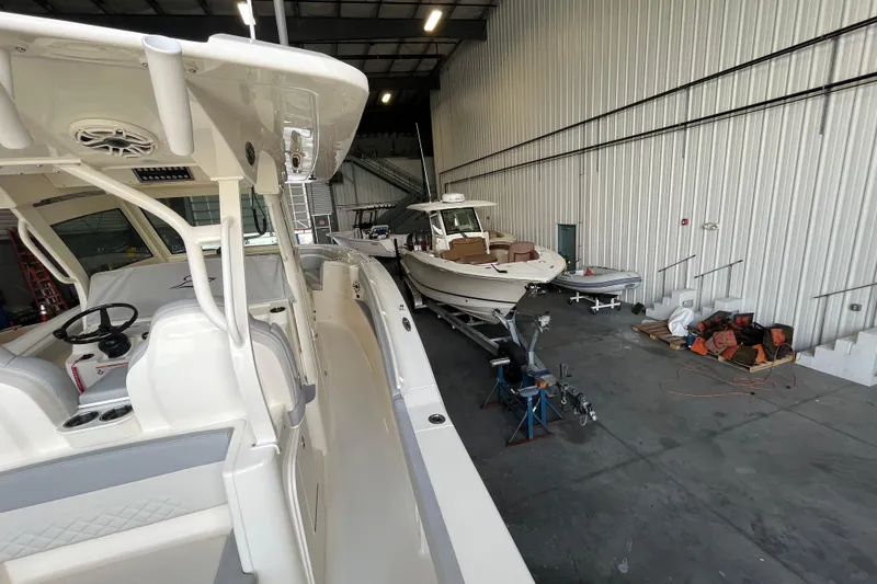 Slide: The Image of 2026 Scout 330 LXF boat in a spacious indoor storage facility. - 15