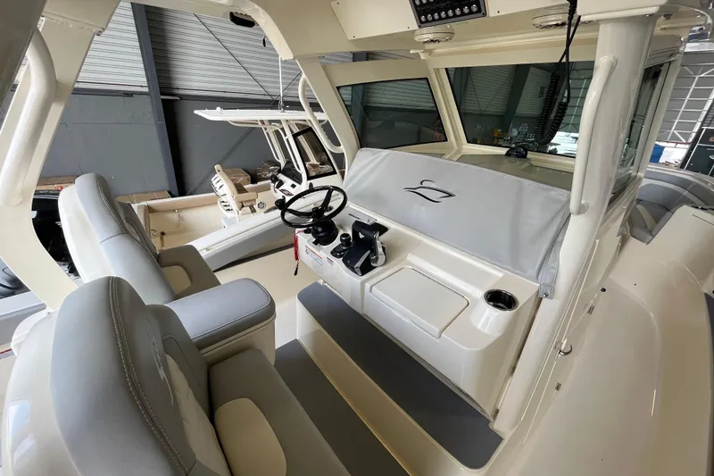 Slide: The Image of 2026 Scout 330 LXF boat interior with helm and seating in a showroom. - 17
