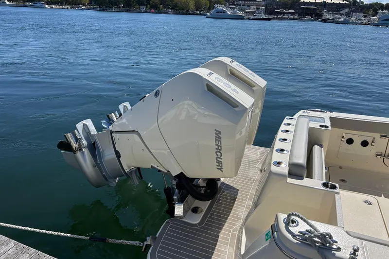 Slide: The Image of 2026 Scout 330 LXF boat with Mercury outboard engines docked by the water. - 3
