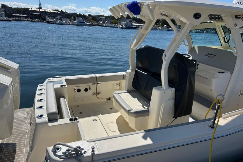 Slide: The Image of 2026 Scout 330 LXF boat interior with seating, docked by the water. - 4