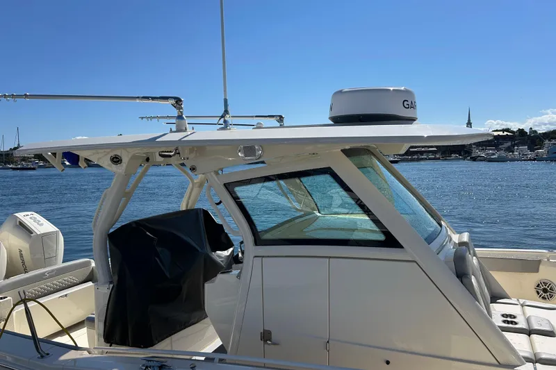 Slide: The Image of 2026 Scout 330 LXF boat docked by the water on a sunny day. - 5