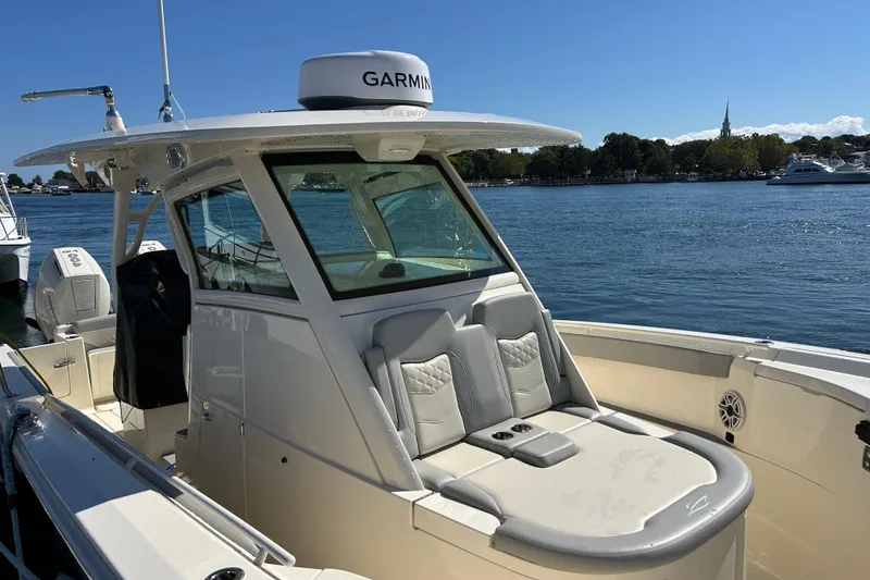Slide: The Image of 2026 Scout 330 LXF boat with Garmin equipment, docked on a sunny day by the water. - 6