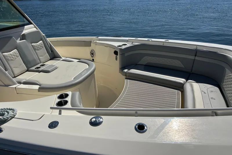 Slide: The Image of Luxurious seating area on 2026 Scout 330 LXF boat, featuring elegant design and ocean backdrop. - 7