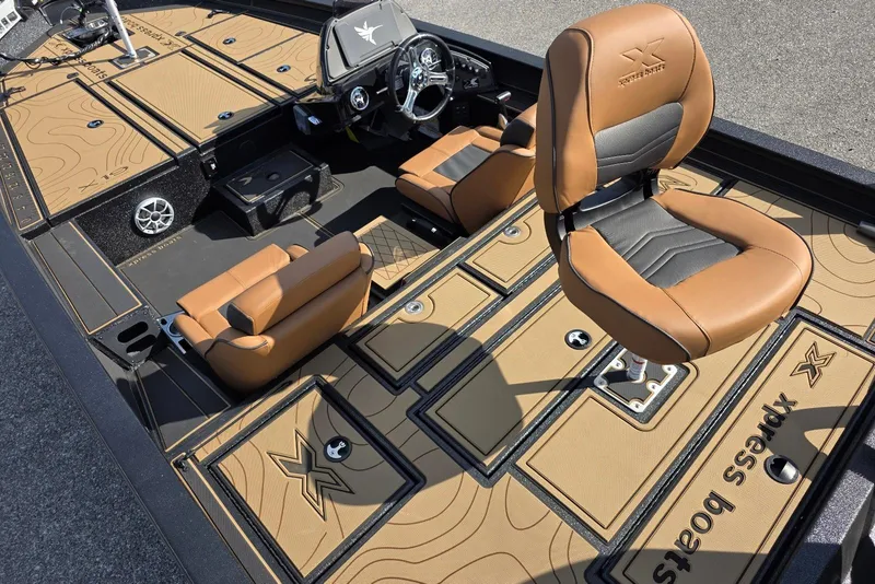 Slide: The Image of 2026 Xpress X19 Pro boat interior with tan and black seating and deck. - 11