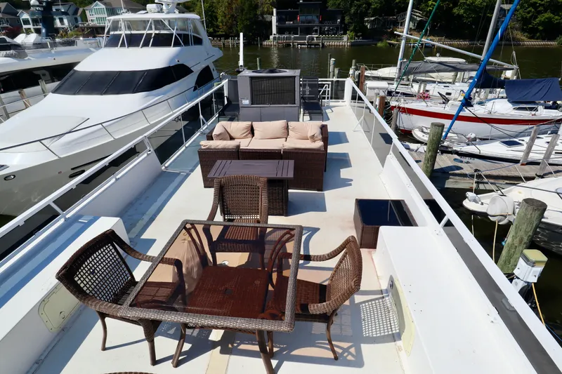 Slide: The Image of Upper deck of 1997 Fun Country Forerunner with outdoor seating, docked near other boats. - 11