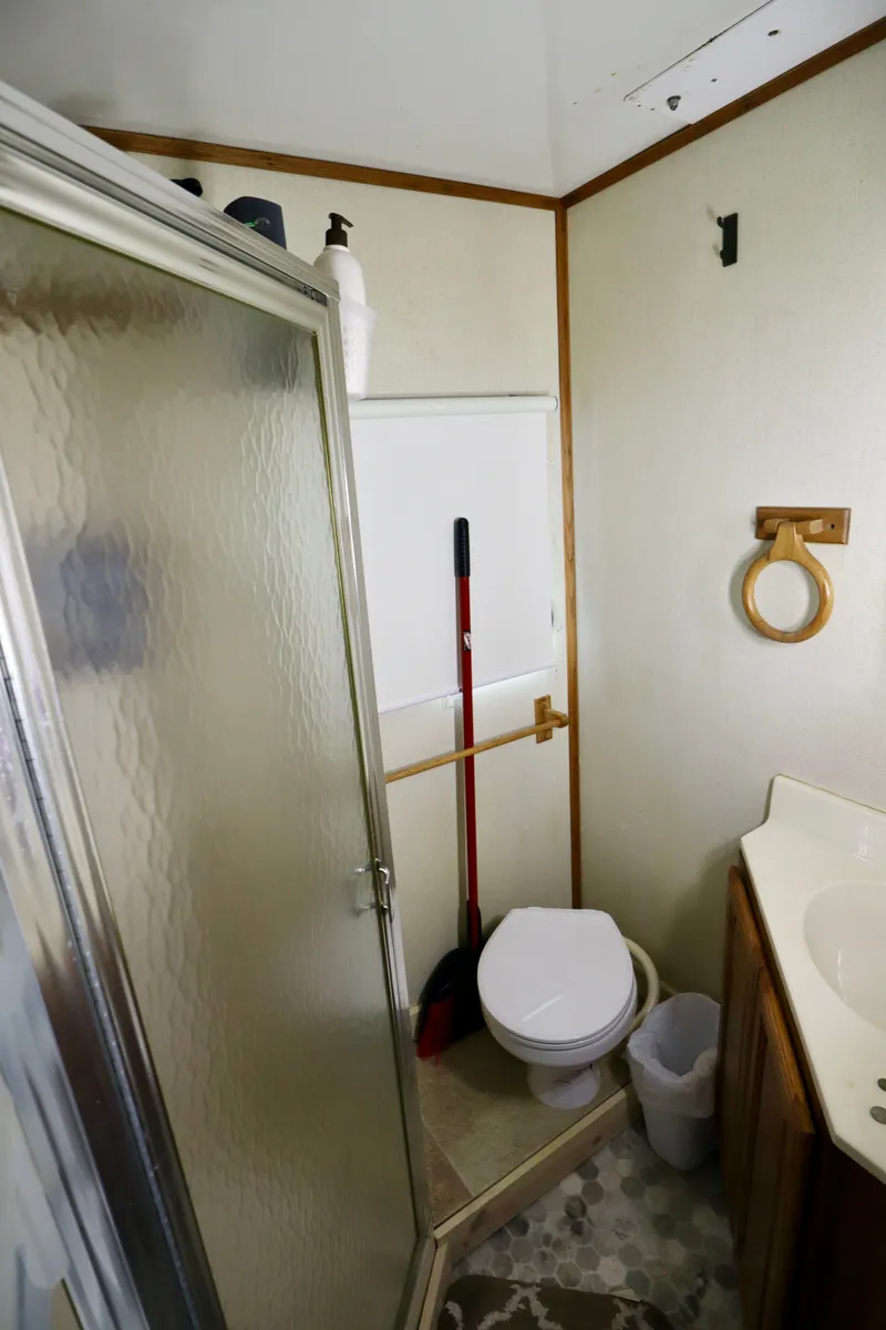 Slide: The Image of Small bathroom in 1997 Fun Country Forerunner RV with shower and toilet. - 16