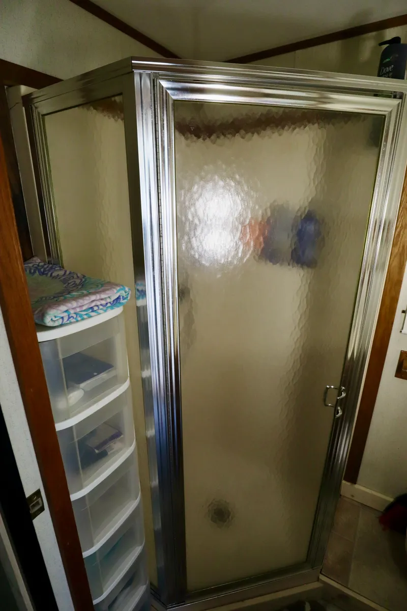 Slide: The Image of Shower stall in 1997 Fun Country Forerunner RV bathroom with storage shelves nearby. - 17