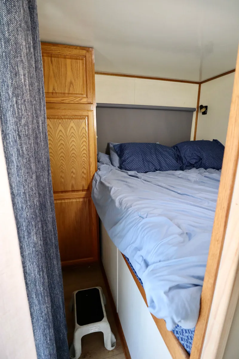 Slide: The Image of Cozy bedroom in 1997 Fun Country Forerunner houseboat with blue bedding and wooden cabinetry. - 19