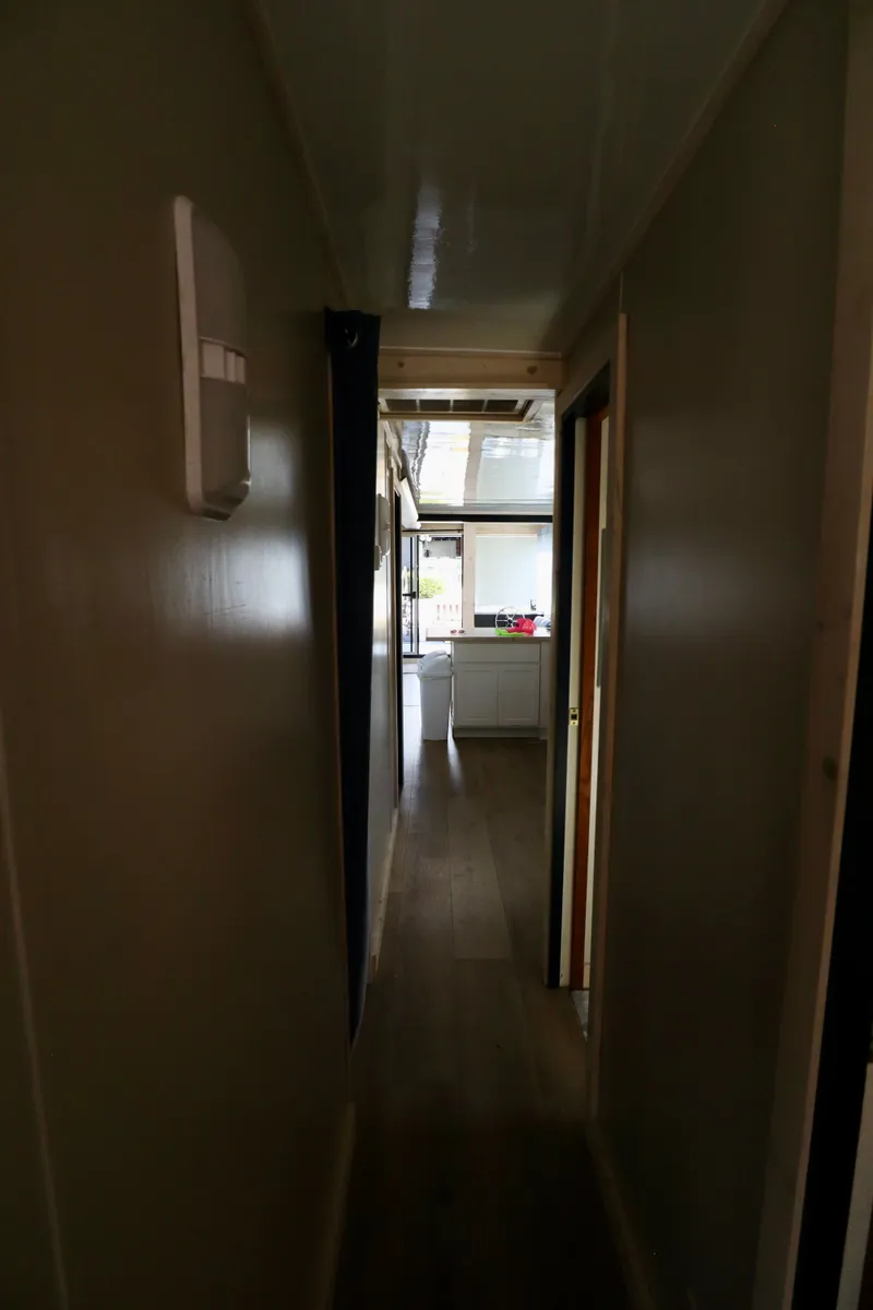 Slide: The Image of Narrow hallway in 1997 Fun Country Forerunner houseboat, leading to a bright kitchen area. - 20