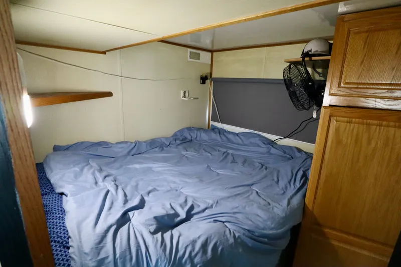 Slide: The Image of Cozy bedroom in 1997 Fun Country Forerunner RV with blue bedding and wooden cabinets. - 24
