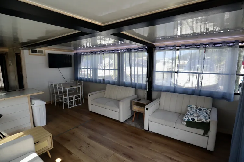 Slide: The Image of Spacious 1997 Fun Country Forerunner houseboat interior with modern furnishings and large windows. - 28