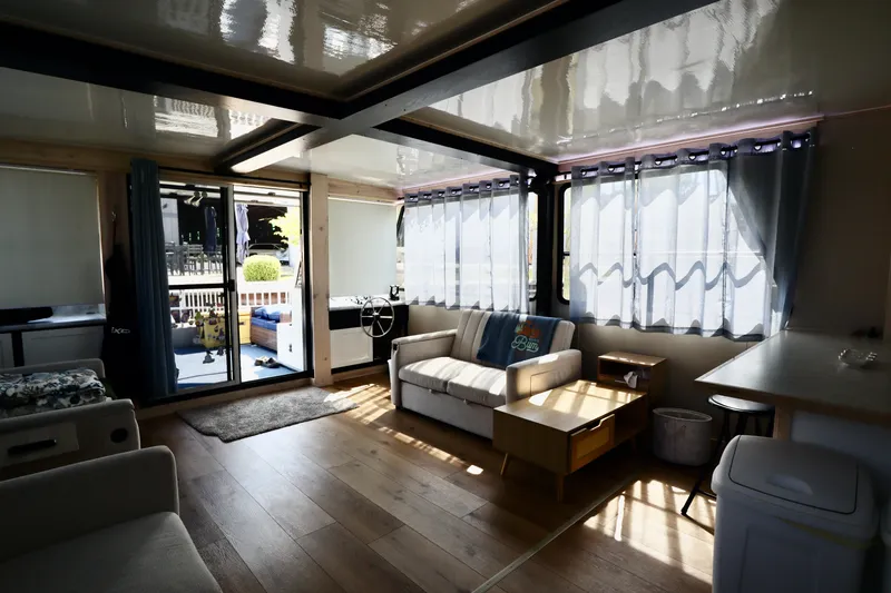 Slide: The Image of Interior of a 1997 Fun Country Forerunner houseboat with cozy seating and large windows. - 29