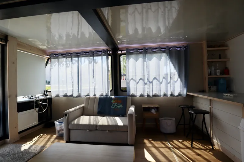 Slide: The Image of Interior of a 1997 Fun Country Forerunner houseboat with cozy seating and kitchen area. - 33