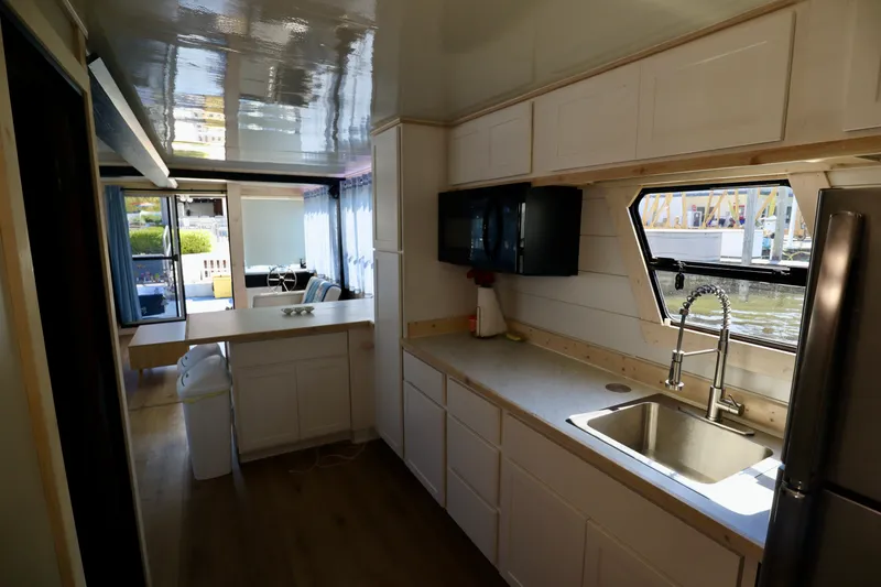 Slide: The Image of Modern kitchen interior in 1997 Fun Country Forerunner houseboat, featuring sleek cabinetry and waterfront view. - 37