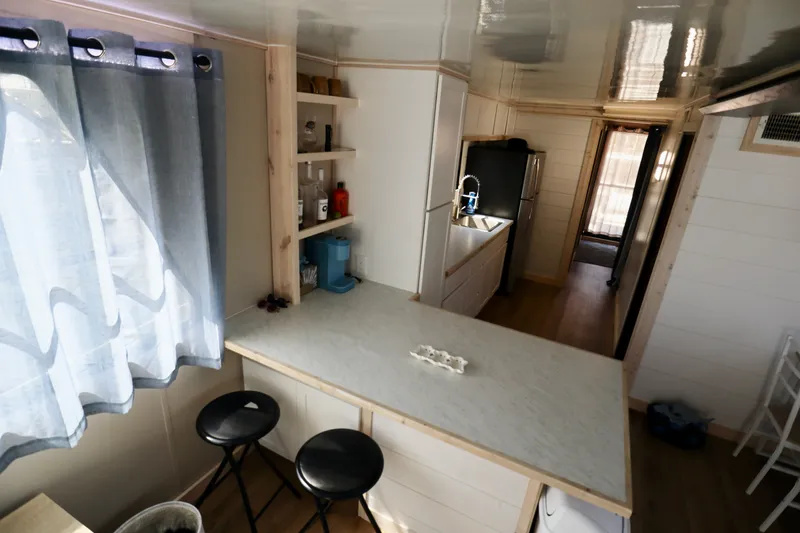 Slide: The Image of Compact kitchen interior in a 1997 Fun Country Forerunner, featuring modern appliances and seating. - 39