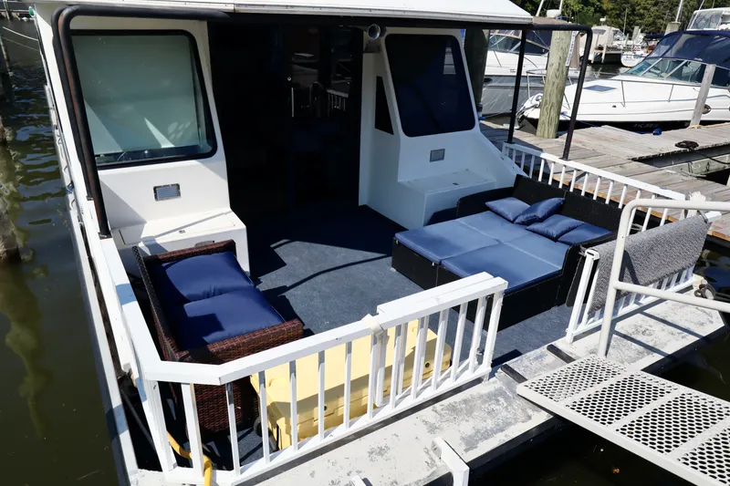 Slide: The Image of Houseboat deck with blue seating, Fun Country Forerunner 1997, docked at marina. - 47
