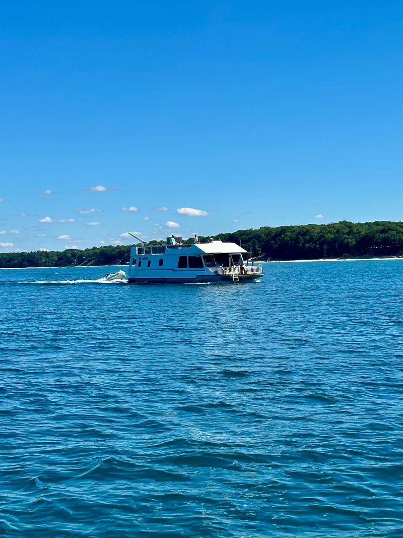 Slide: The Image of Houseboat cruising on a lake under clear blue skies, Fun Country Forerunner 1997 model. - 6