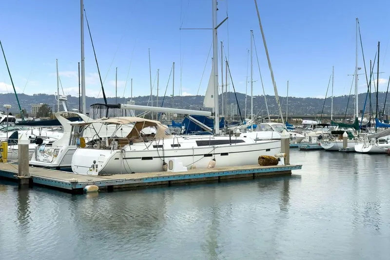 The Image of 2016 Bavaria 51 Cruiser yacht docked in a marina, surrounded by other sailboats. - 0