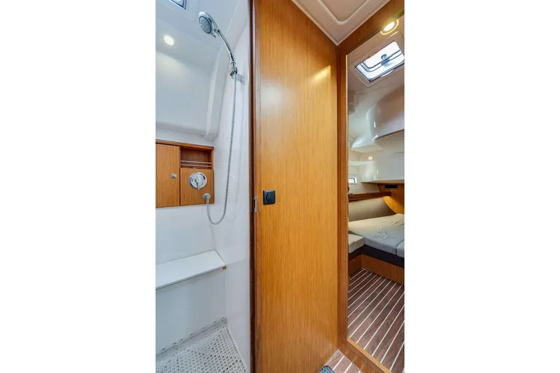 Slide: The Image of Interior of 2016 Bavaria 51 Cruiser yacht, featuring a shower and cozy cabin. - 11