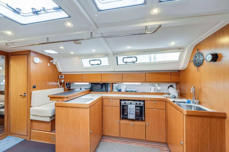 Slide: The Image of Interior of 2016 Bavaria 51 Cruiser yacht with modern kitchen and wooden cabinetry. - 16