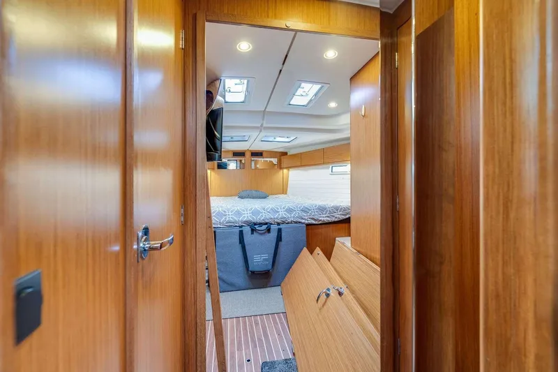 Slide: The Image of Interior of 2016 Bavaria 51 Cruiser yacht, featuring a cozy wooden cabin and bed. - 17