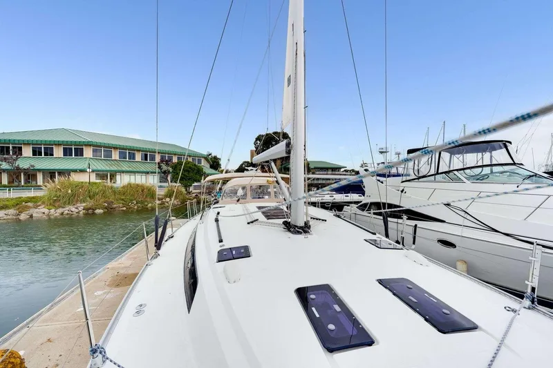 Slide: The Image of 2016 Bavaria 51 Cruiser yacht docked at marina, clear sky, waterfront building. - 2