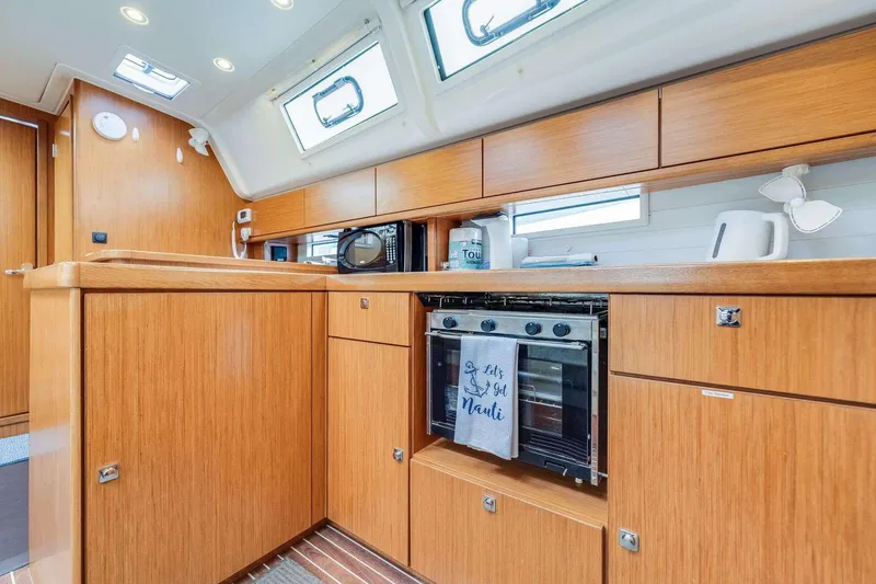 Slide: The Image of Modern kitchen interior of 2016 Bavaria 51 Cruiser yacht with wooden cabinetry and appliances. - 24