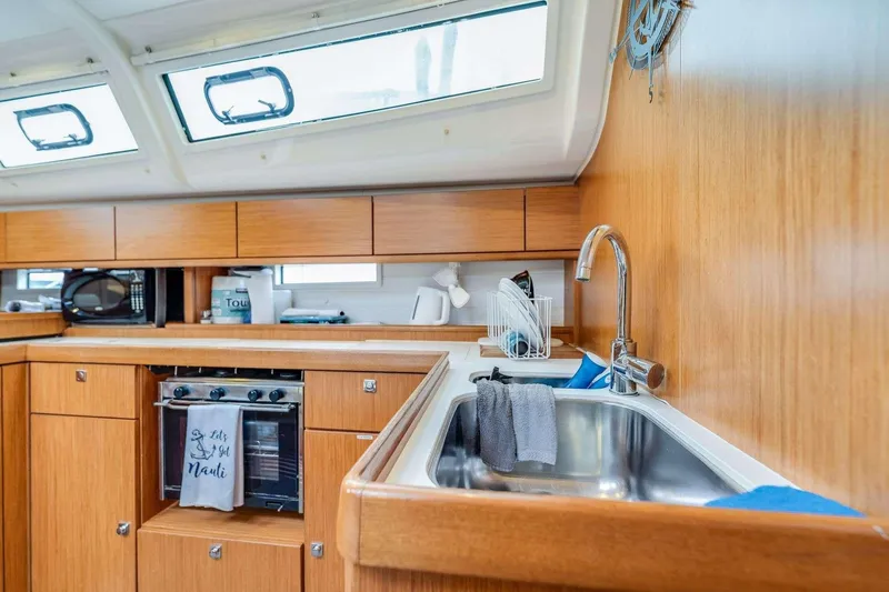 Slide: The Image of Modern kitchen interior of 2016 Bavaria 51 Cruiser yacht with wooden cabinetry and stainless steel sink. - 25
