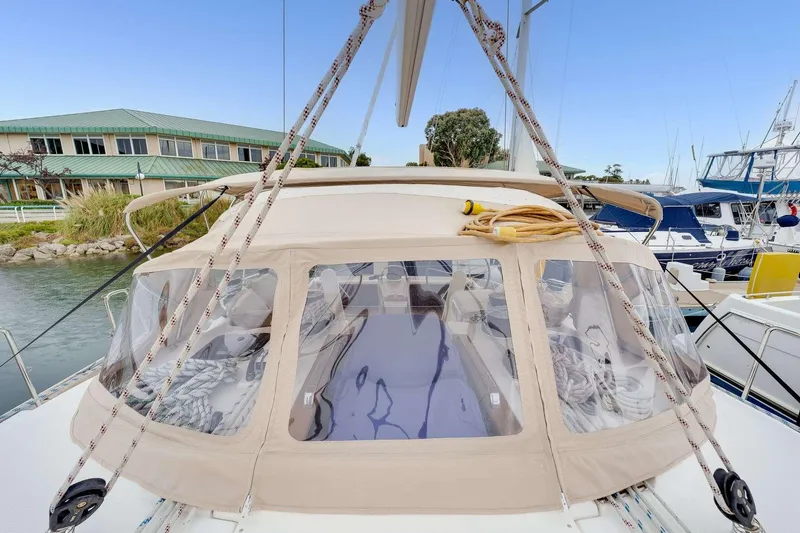 Slide: The Image of 2016 Bavaria 51 Cruiser yacht docked at marina with beige canopy and clear windows. - 4