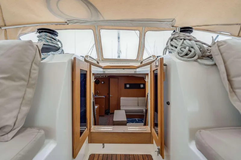 Slide: The Image of Interior view of 2016 Bavaria 51 Cruiser yacht, featuring cozy seating and wooden accents. - 5