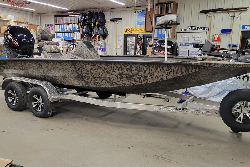 The Image of 2026 Xpress X19 Pro boat on trailer in a workshop setting. - 1