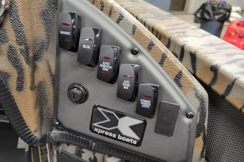 Slide: The Image of Control panel of 2026 Xpress X19 Pro boat with various switches and logo. - 9